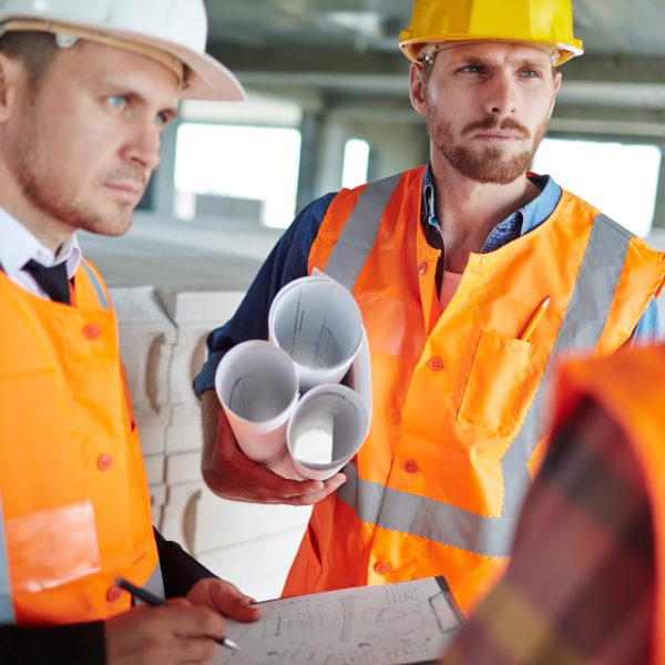 Young architects in uniform discussing what to do next